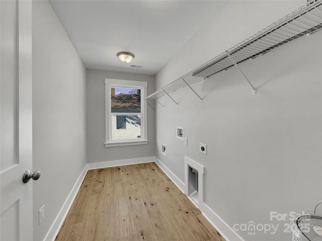 laundry area featuring electric dryer hookup, hookup for a washing machine, and light hardwood / wood-style floors