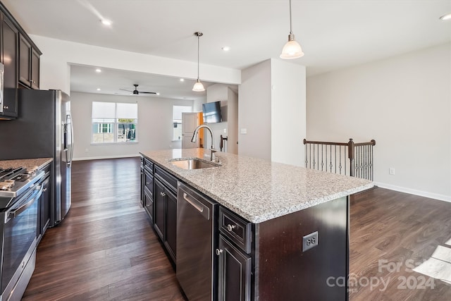 kitchen featuring sink, a kitchen island with sink, pendant lighting, and dark hardwood / wood-style flooring