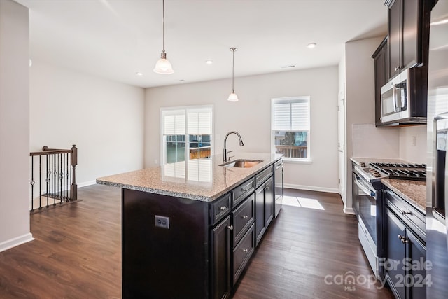 kitchen featuring sink, a kitchen island with sink, stainless steel appliances, and a healthy amount of sunlight