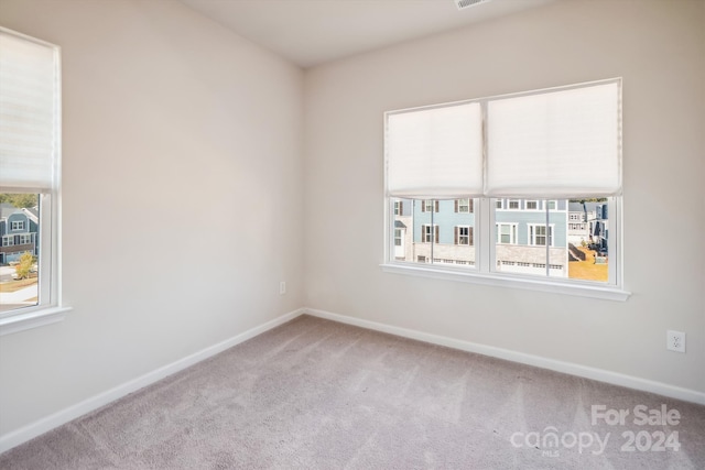 unfurnished room featuring light colored carpet