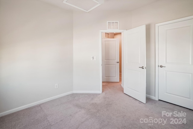 unfurnished bedroom featuring light carpet