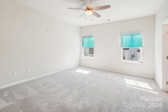 carpeted spare room with a wealth of natural light and ceiling fan