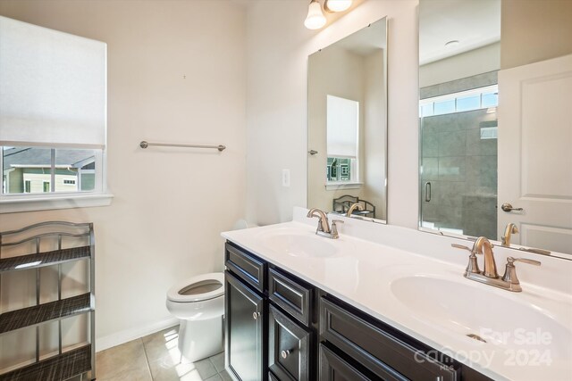 bathroom featuring vanity, toilet, walk in shower, and tile patterned flooring