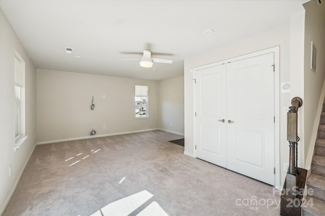 unfurnished bedroom with light colored carpet, a closet, and ceiling fan