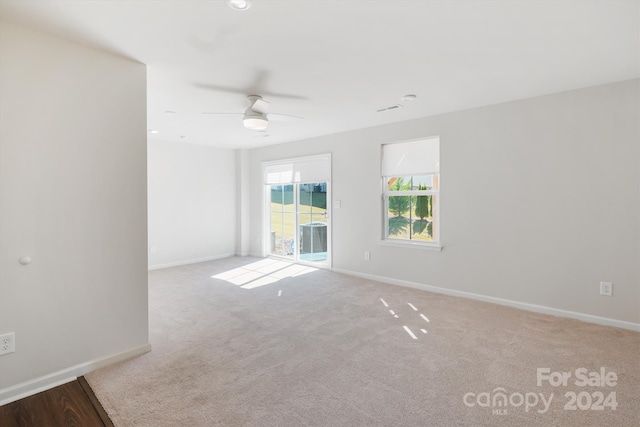 spare room featuring light carpet and ceiling fan