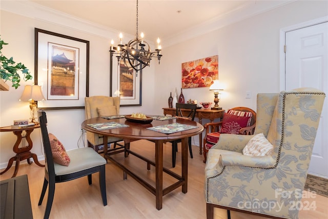 dining area with crown molding, light hardwood / wood-style flooring, and a chandelier