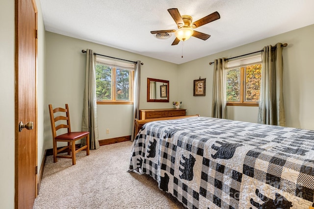 carpeted bedroom with a textured ceiling and ceiling fan