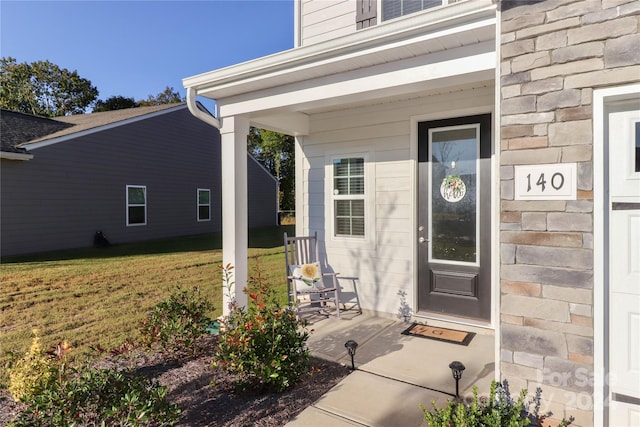 property entrance with a lawn