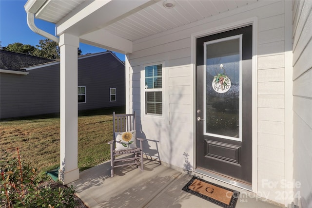 property entrance with a lawn