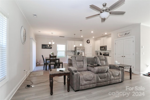 living room featuring ornamental molding, ceiling fan with notable chandelier, and light wood-type flooring