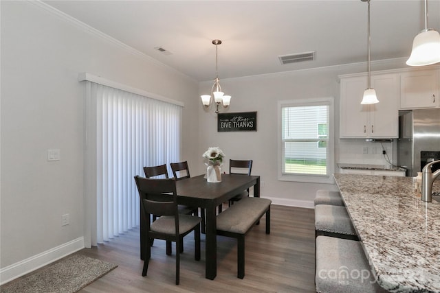 dining room featuring ornamental molding, an inviting chandelier, and hardwood / wood-style floors