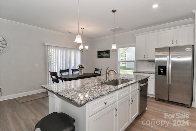 kitchen with white cabinets, an island with sink, appliances with stainless steel finishes, light hardwood / wood-style flooring, and sink