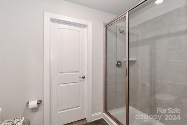 bathroom with toilet, hardwood / wood-style flooring, and walk in shower