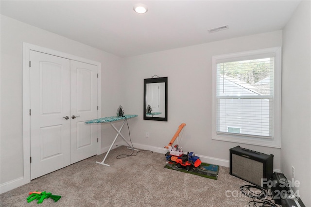 miscellaneous room featuring light colored carpet