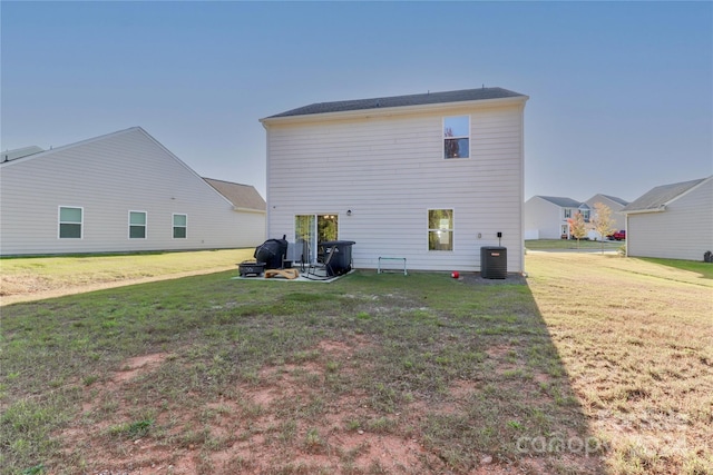 rear view of property featuring a yard and central AC unit