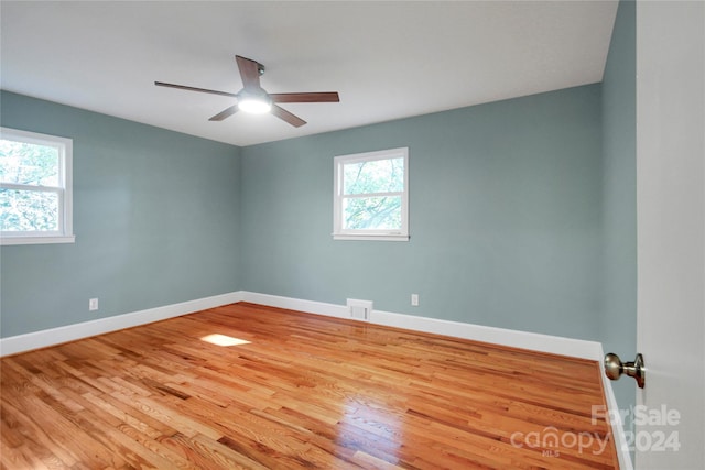 empty room with a healthy amount of sunlight, light wood-type flooring, and ceiling fan