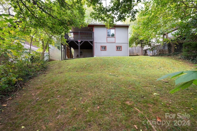 back of house featuring a deck and a lawn