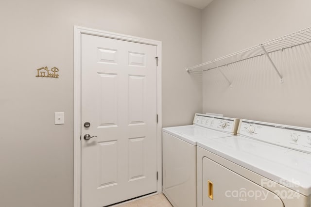 laundry area with light tile patterned flooring and washing machine and dryer