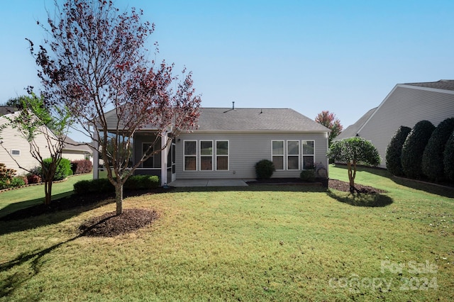 back of property with a lawn and a patio area