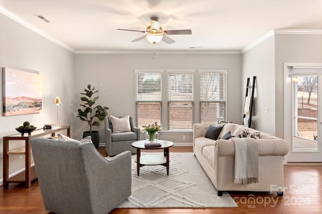 living room with hardwood / wood-style flooring, ceiling fan, and crown molding