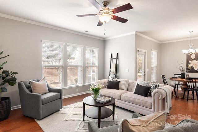 living room with crown molding, ceiling fan with notable chandelier, and hardwood / wood-style flooring