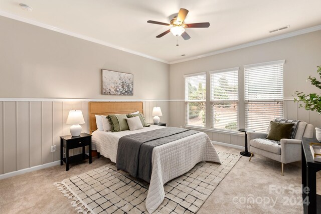 bedroom featuring ceiling fan, light colored carpet, and ornamental molding