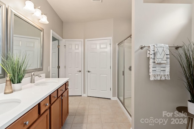 bathroom with tile patterned floors, vanity, and a shower with shower door