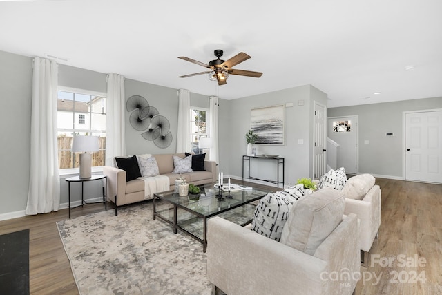 living room featuring ceiling fan, light wood-type flooring, and plenty of natural light