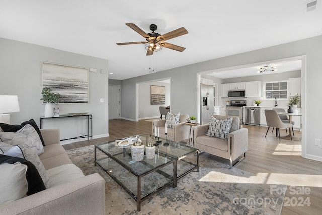 living room featuring light wood-type flooring and ceiling fan