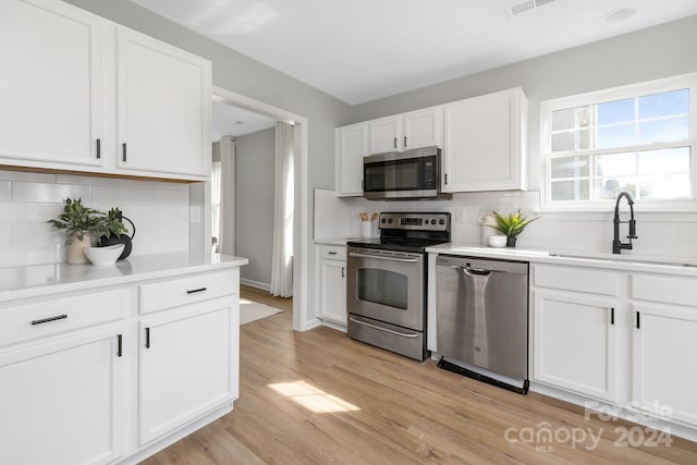 kitchen featuring light hardwood / wood-style floors, white cabinets, stainless steel appliances, and sink