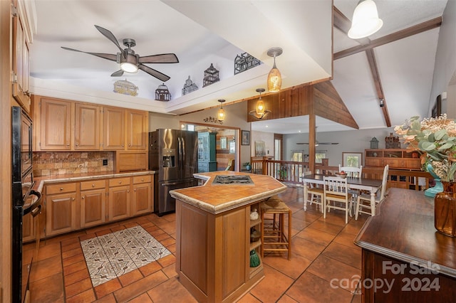 kitchen with ceiling fan, stainless steel fridge, a kitchen island, and a healthy amount of sunlight