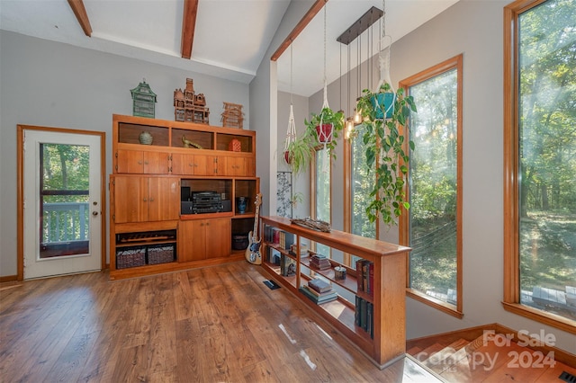 office area with beam ceiling, a wealth of natural light, and hardwood / wood-style flooring