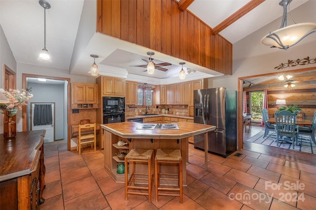 kitchen featuring tasteful backsplash, a kitchen island, plenty of natural light, and black appliances