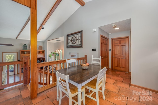 tiled dining room with beamed ceiling and high vaulted ceiling