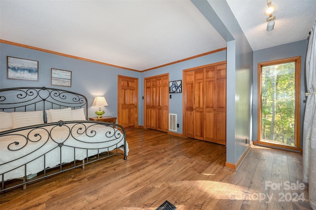 bedroom featuring light wood-type flooring and crown molding