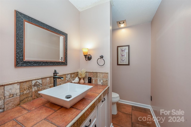 bathroom with vanity, a textured ceiling, and toilet