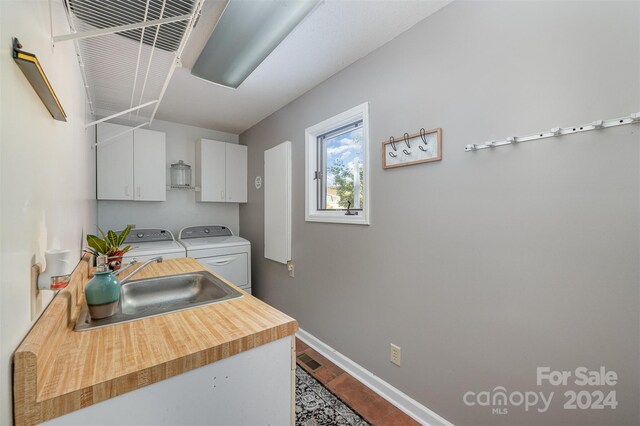 laundry room with washer and clothes dryer, cabinets, and sink