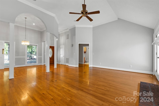 unfurnished living room featuring crown molding, ceiling fan with notable chandelier, hardwood / wood-style flooring, and high vaulted ceiling