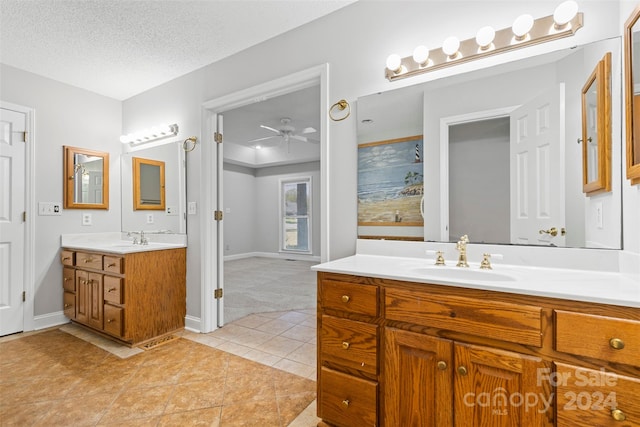 bathroom featuring tile patterned flooring, a shower, vanity, a textured ceiling, and ceiling fan