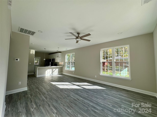 unfurnished living room featuring dark hardwood / wood-style floors and ceiling fan