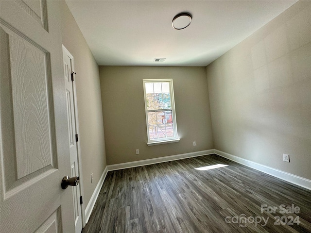 empty room with dark hardwood / wood-style flooring