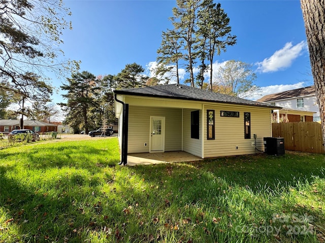 back of property with a patio area, central AC unit, and a lawn