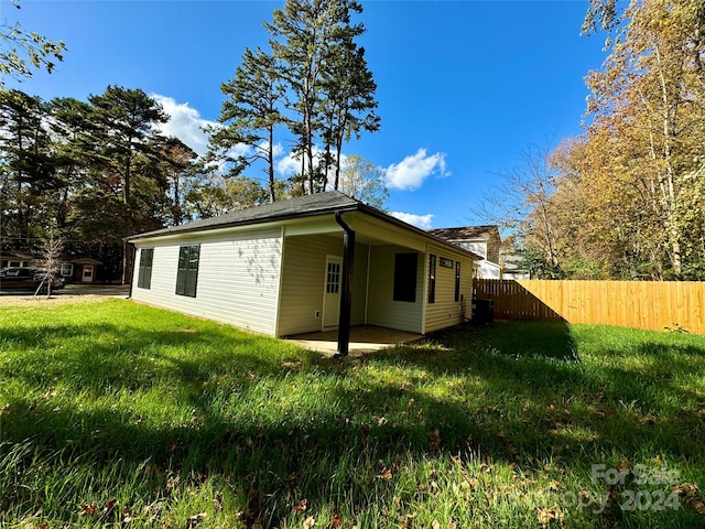 view of side of home featuring a patio area and a yard