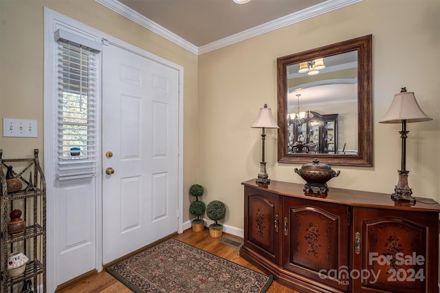 entryway with crown molding and light hardwood / wood-style floors