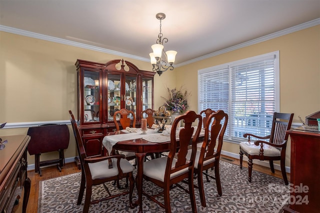 dining space featuring crown molding, a notable chandelier, and dark hardwood / wood-style flooring