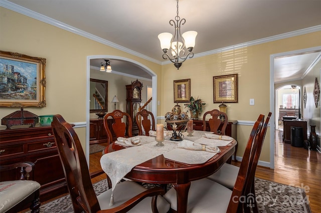 dining area with crown molding, wood-type flooring, and a chandelier