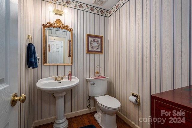 bathroom featuring toilet, sink, and wood-type flooring