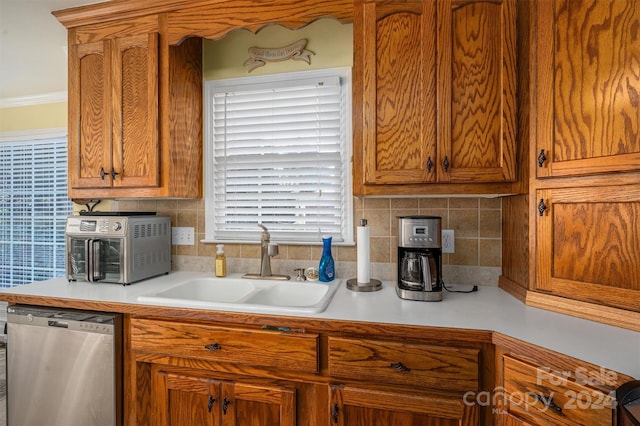 kitchen featuring sink, dishwasher, ornamental molding, and backsplash