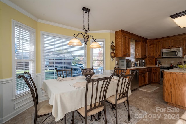 dining area featuring ornamental molding, sink, and a wealth of natural light