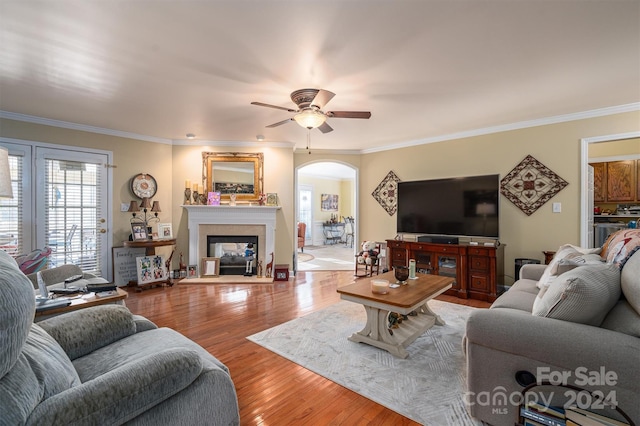 living room featuring ceiling fan, hardwood / wood-style flooring, and ornamental molding